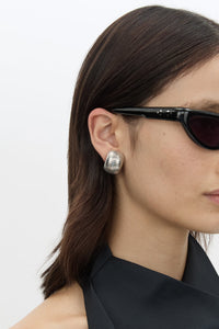 Styled view CAMILLA AND MARC Connor Earrings in silver rhodium‑plated brass with geometric design.