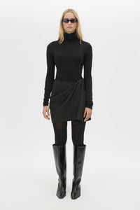 Front styled view CAMILLA AND MARC Mackinley Mini Wrap Skirt in Black with a draped low‑rise silhouette.