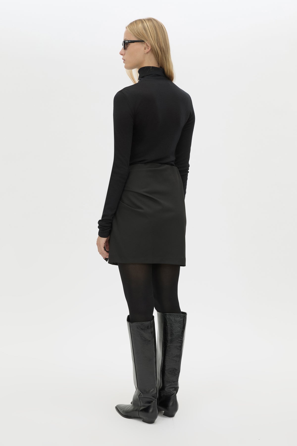 Back view CAMILLA AND MARC Mackinley Mini Wrap Skirt in Black with a draped low‑rise silhouette.