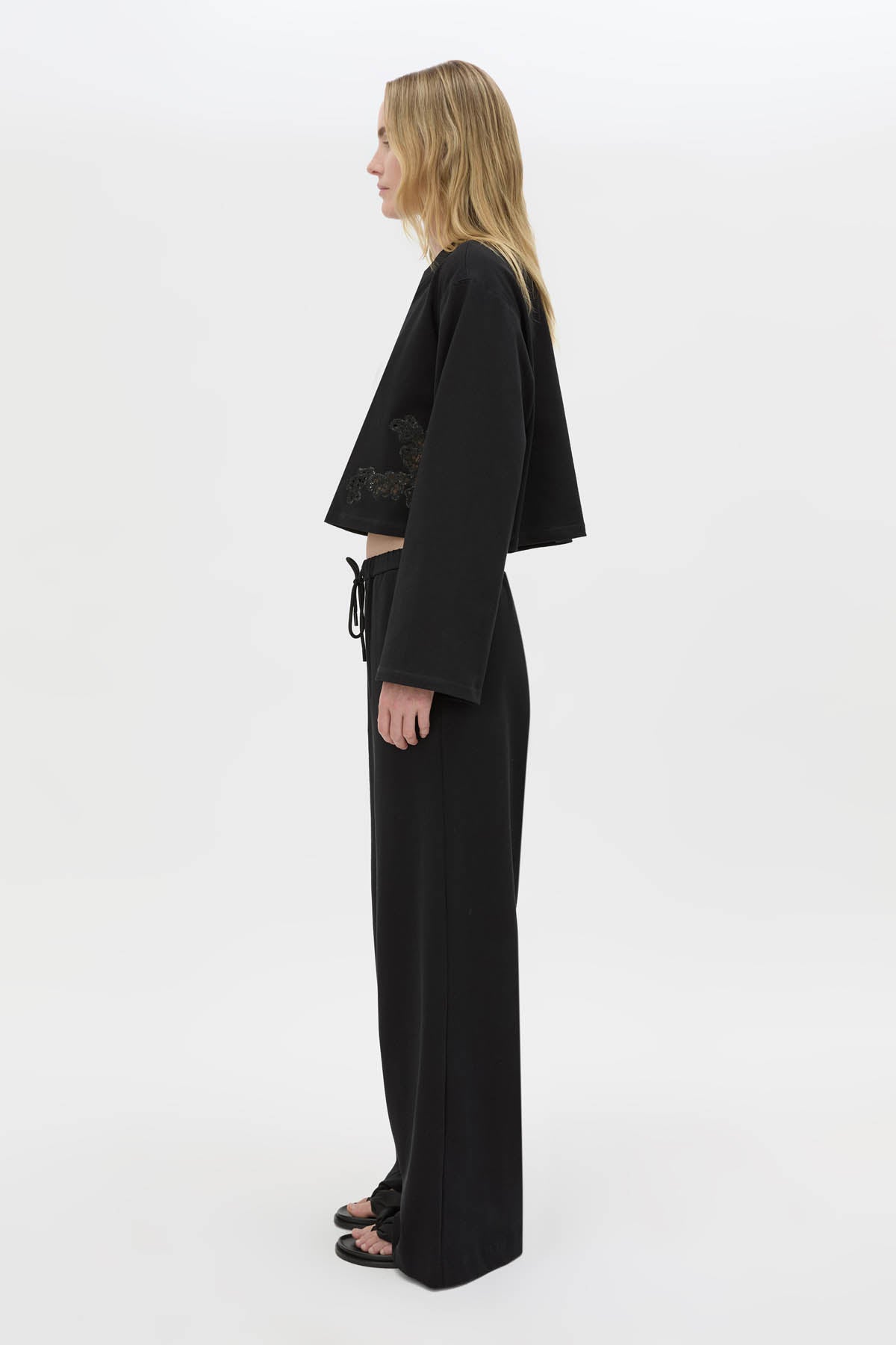 Side view CAMILLA AND MARC Niami Crochet Cropped Top in black with cut‑away crochet detailing at hem.