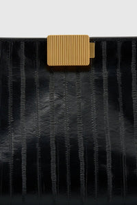 Cropped view CAMILLA AND MARC Poppy Eel Clutch in Black eel‑embossed leather with ribbed gold hardware.