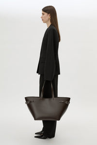 Front styled view CAMILLA AND MARC Willa Tote in Chocolate Brown with side strap and buckle detailing and magnetic button closure.