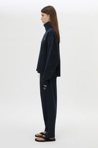 Side view CAMILLA AND MARC Zylus funnel neck pullover sweater in navy/white with contrast embroidered monogram. 